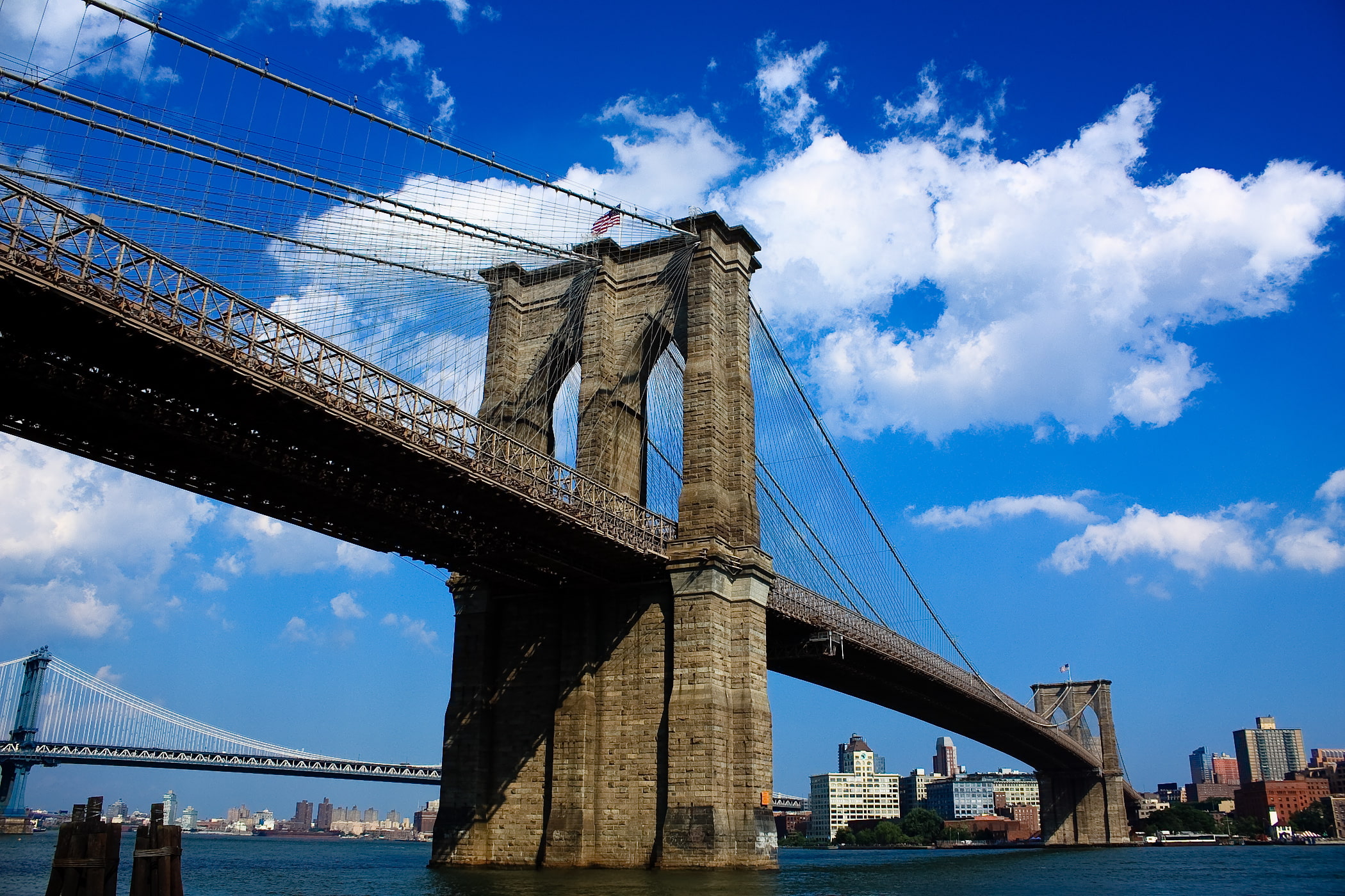 Sunny blue skies riverside view of Brooklyn bridge